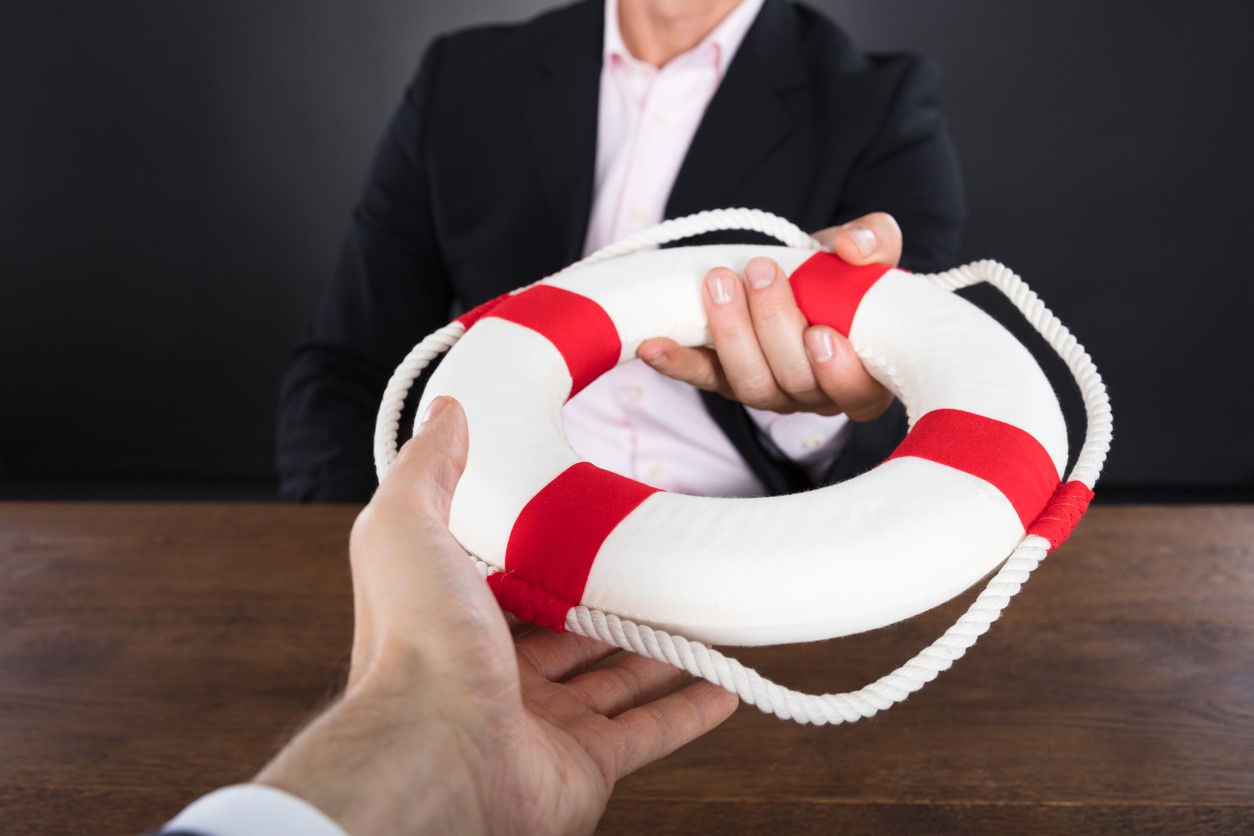 Business Coach Passing A Life Preserver To A Client To Help Solve His Cash Flow Problems
